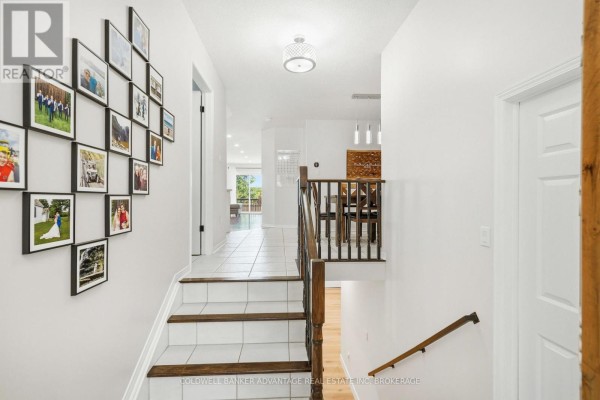 Staircase with white tiled risers and wooden treads leading to the main living area. - 529 St Lawrence Drive, Welland