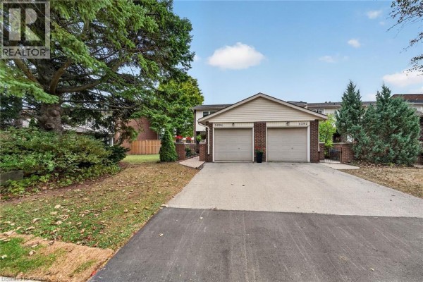 Exterior view of brick townhouses with double garages and landscaping. - 5294 Bromley Road, Burlington