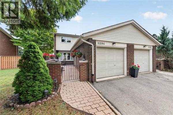 Exterior view of two-story townhouse with brick and siding, featuring double garage. - 5294 Bromley Road, Burlington