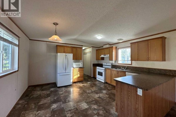 Open kitchen layout featuring dining area and ample counter space. - 53, 6205 54 Street, Ponoka