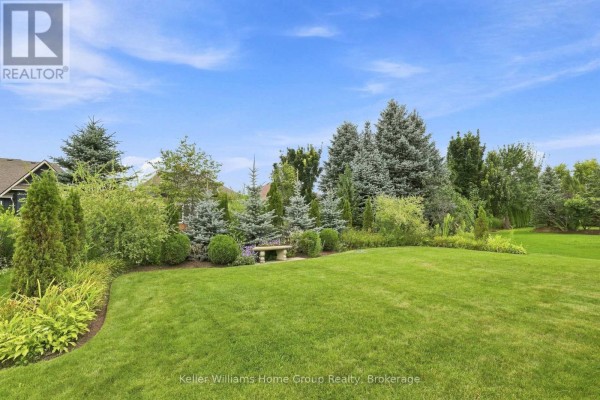 Manicured lawn with stone bench and mature trees - 53 - 145 Aberfoyle Mill Crescent Puslinch