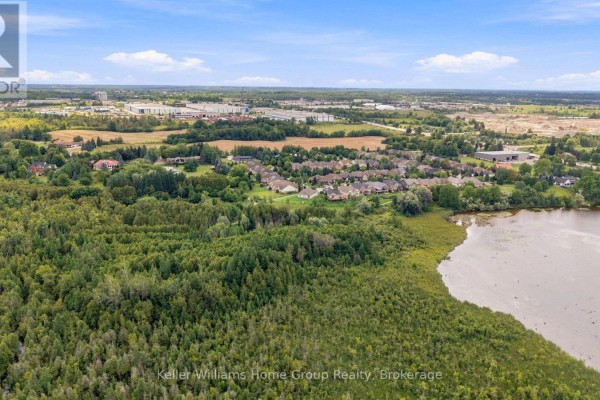 Aerial view of suburban neighborhood with lake and wooded area - 53 - 145 Aberfoyle Mill Crescent Puslinch