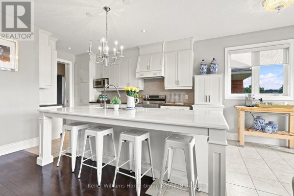 White island kitchen with bar stools, shaker cabinets, stainless steel appliances, and chandelier - 53 - 145 Aberfoyle Mill Crescent Puslinch