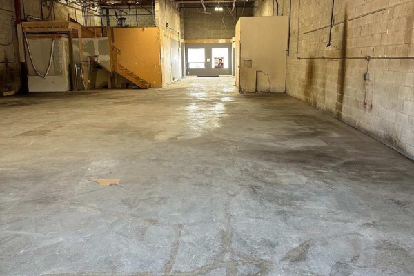 Interior view of large, empty commercial space with concrete floors and cinder block walls. - 53 - 173 Advance Boulevard, Brampton