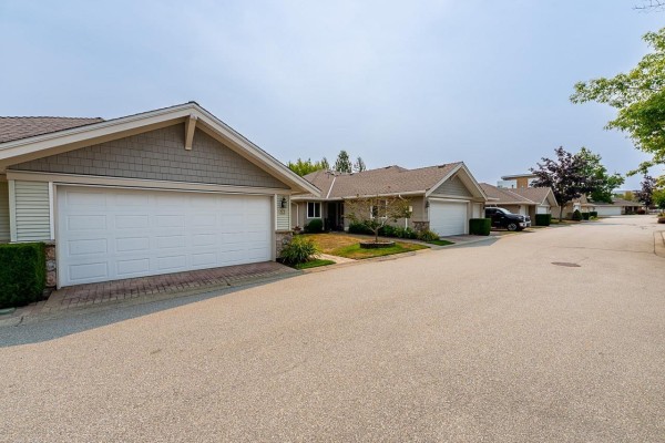 Exterior walkway with brick pavers leading to the townhouse entrance with light green siding. - 53 17516 4 Avenue, Surrey