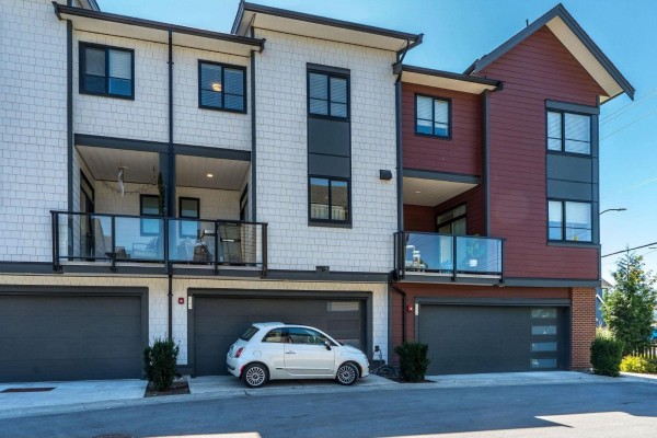 Cozy living area featuring a sectional sofa, large window, and decorative elements. - 53 19897 75a Avenue, Langley