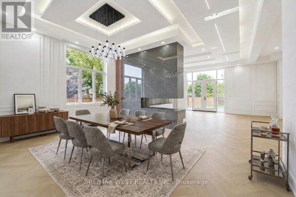 Living room with a large window, light wood herringbone floors, and built-in light wood cabinets and shelves. - 53 Celt Avenue, Toronto