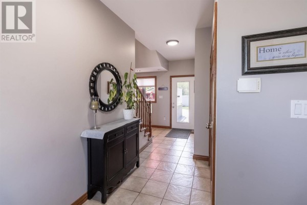 Lavender bedroom with queen bed, white dresser, and two white double closet doors. - 53 Laura St, Sault Ste  Marie
