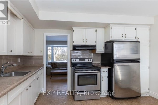 Kitchen with white cabinets, stainless steel appliances, and a subway tile backsplash. - 53 Madeira Drive, London East