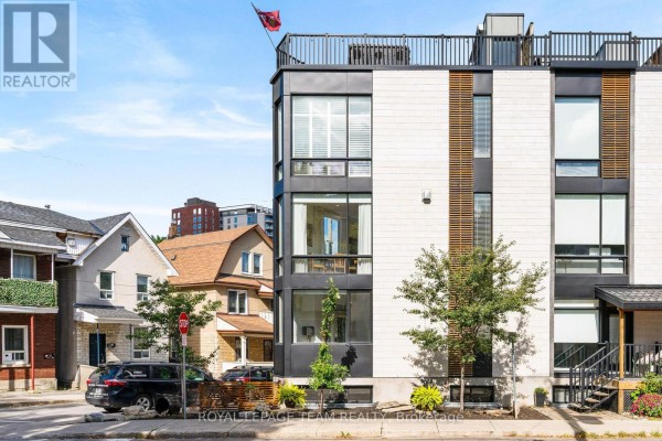 Close-up exterior view of a corner townhouse with large windows and modern facade. - 53 Merton Street, Ottawa