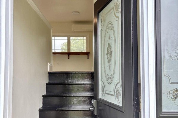 View from doorway looking up black stairs to a window with a wooden shelf. - 53 Mood Road, Pleasant Lake