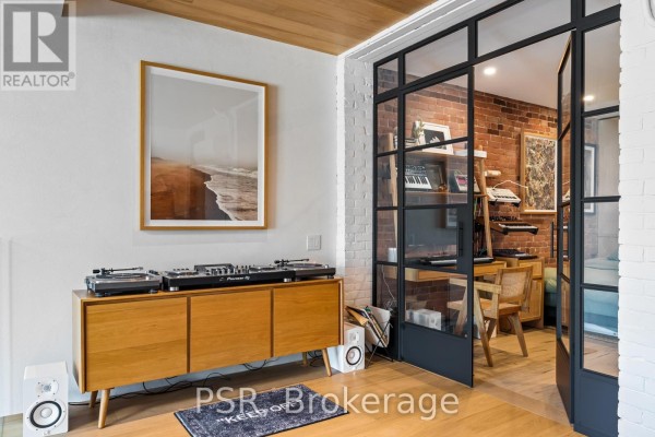 Wooden credenza with turntables & speakers, glass doors to brick room - 53 Palmerston Avenue Toronto