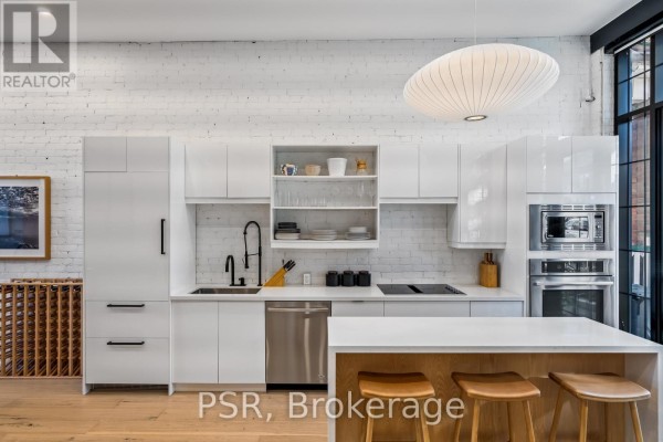 Modern kitchen with white brick backsplash, island, and pendant light - 53 Palmerston Avenue Toronto