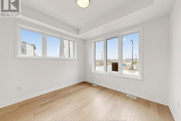Interior room with white walls, recessed lighting, and large windows with a view of the street. - 53 Sage Valley Drive, Markham