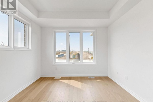 Interior room with white walls, recessed ceiling, and large windows with a view of the street. - 53 Sage Valley Drive, Markham