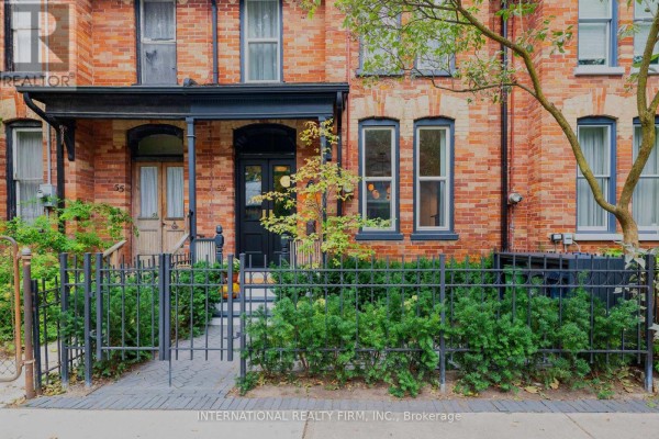 View of the front porch with black railing, stairs, and foliage. - 53 Spruce Street, Toronto