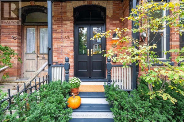 Front door entrance with double black doors, pumpkin, and potted flowers. - 53 Spruce Street, Toronto