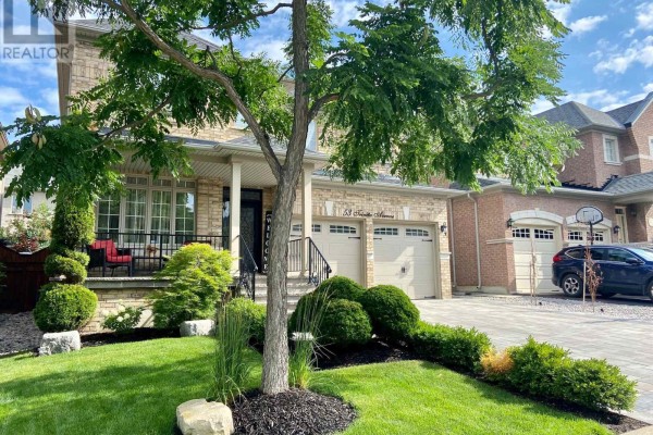Exterior of a large brick house with a double garage and a well-landscaped front yard with a mature tree. - 53 Trinita Avenue, Vaughan