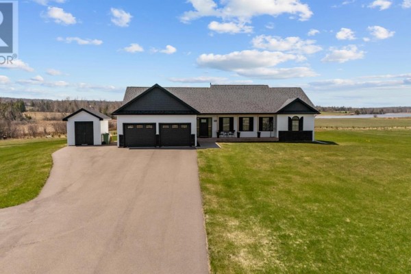 Front view of a white residential house with a two-car garage, dark trim, and stone accents. - 53 Westville Road, New Dominion