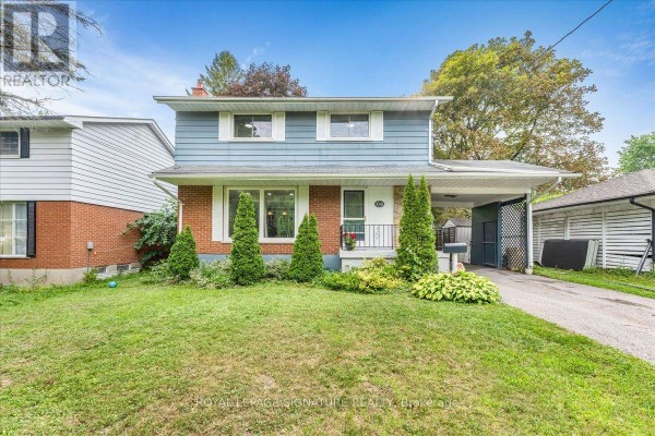 A two-story brick and light blue siding house with a covered carport and green lawn. - 530 Brentwood Avenue, Oshawa