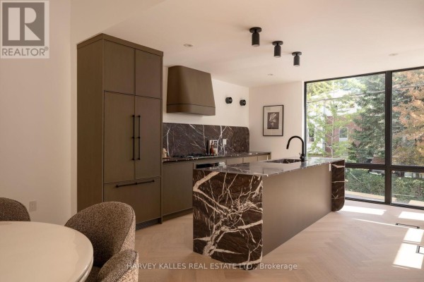 Kitchen with dark green cabinetry, marble countertops, an island, and a large window. - 530 Duplex Avenue, Toronto