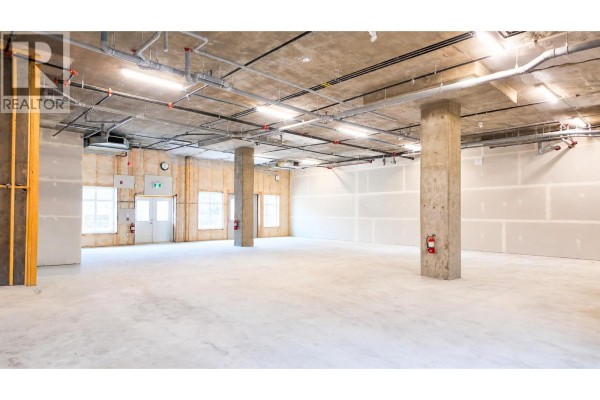 Spacious unfinished commercial interior with concrete columns, exposed ceiling utilities, and drywall. - 5300 Main Street Unit# 40 & 50, Kelowna