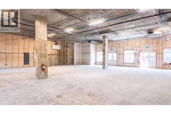 Wide view of an unfinished commercial unit showing concrete floor, columns, and utility infrastructure. - 5300 Main Street Unit# 40 & 50, Kelowna