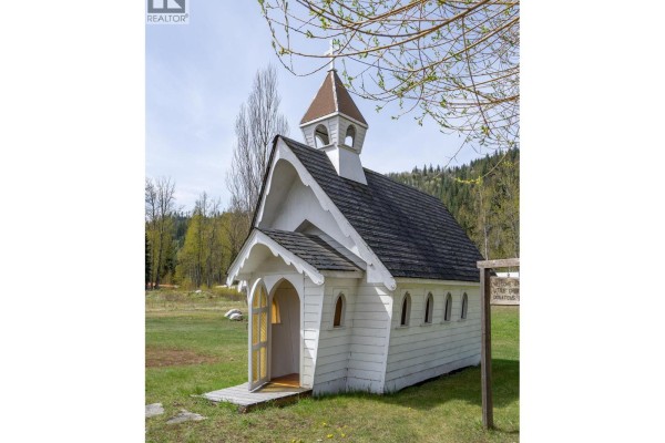 Small white wooden chapel with a steeple and open door, set in a grassy field. - 5301(2-10)-5317-5323-5327 Prosh Frontage Road, Craigellachie