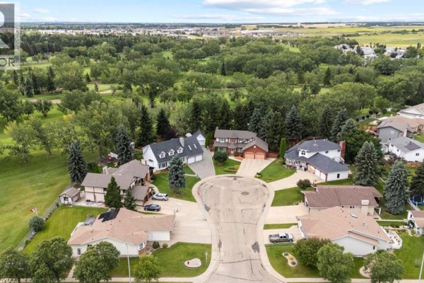 Aerial view of a suburban neighborhood with houses, streets, and a golf course. - 5302 61 Street Close, Camrose