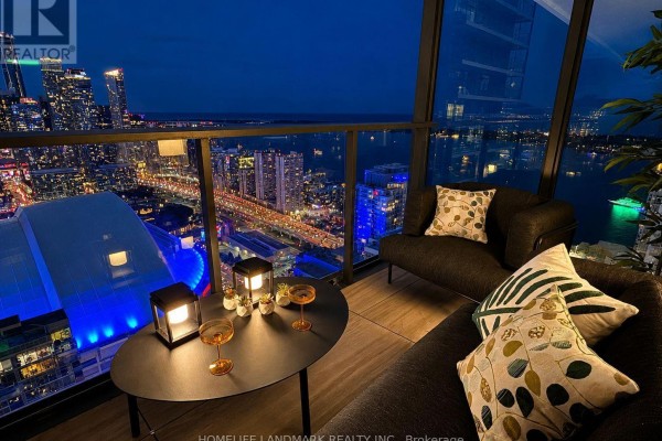 Balcony with seating and city view at night, featuring patterned pillows. - 5309 - 3 Concord Cityplace Way, Toronto