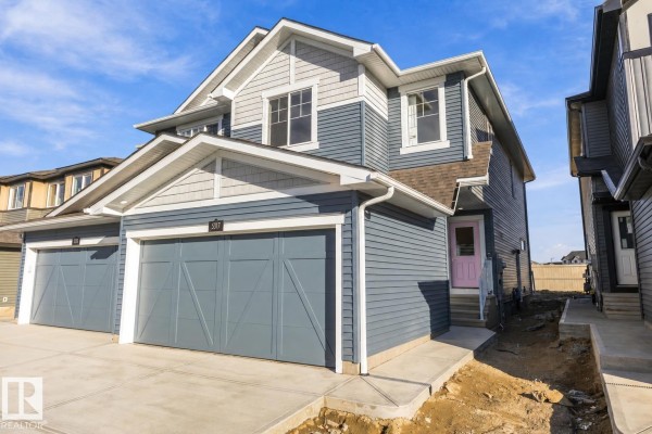 Architectural drawing of a duplex showing the front elevation with two garage doors and windows. - 5317 Hawthorn Cl Sw, Edmonton