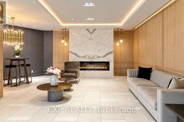 Lobby seating area with a fireplace, modern sofa, chair, and decorative lighting. - 532 - 621 Sheppard Avenue E, Toronto