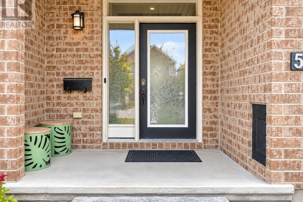 Front door entrance with a black door, glass inserts, and brick facade. - 534 Grand Tully Way, Ottawa