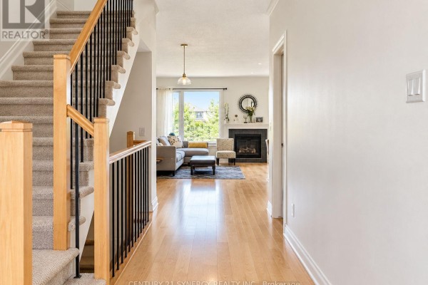 View of the entrance hall with a staircase, wood floors, and open living area. - 534 Grand Tully Way, Ottawa