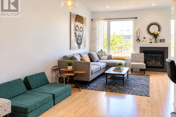 Living room with a large sectional sofa, fireplace, and large window. - 534 Grand Tully Way, Ottawa