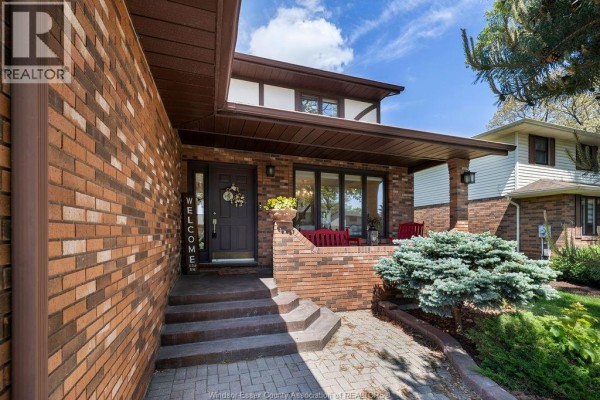 Entrance to the house with brick steps, a covered porch, and red chairs. - 534 Michael Crescent, Lasalle