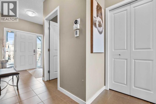 Foyer with white front door, beige walls, white doors, and a framed artwork. - 534 River Heights Crescent, Cochrane