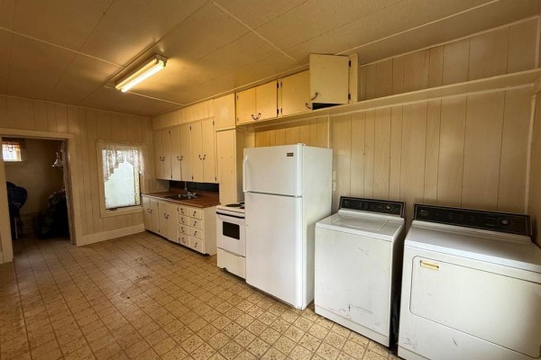 Room with beige carpet, a ceiling fan, a large window showing green trees, and a heater. - 535 Curwen Street, Cartwright