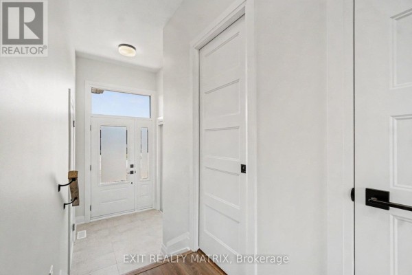 Hallway with entryway, double doors, frosted glass windows, and white doors. - 535 Regina Street, Russell