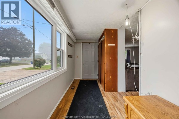 Interior entryway with a large window, wood-look laminate flooring, and a wooden closet. - 535 Richmond Street, Dresden