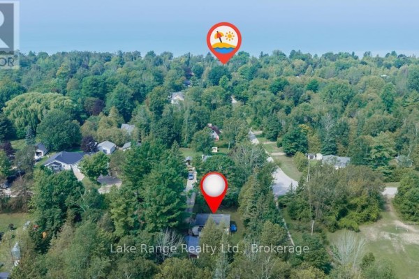Aerial view of the residential area showing the property surrounded by trees, with a distant view of Lake Huron. - 536 Alfred Street, Huron Kinloss
