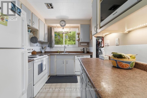 Kitchen with white appliances and cabinets, sink, and window view - 536 Alfred Street Huron Kinloss