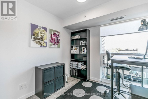 Home office space with a desk, chair, bookshelf, storage cubes, and artwork on the wall. - 538 - 68 Abell Street, Toronto