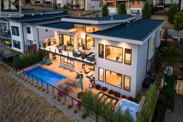 Aerial view of a luxury home's backyard, featuring a pool, hot tub, outdoor kitchen, and expansive deck. - 538 Clifton Court, Kelowna