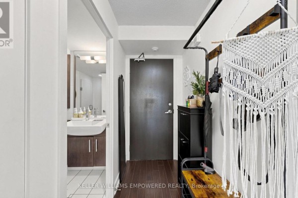 Apartment entryway with dark wood floors, white walls, and a dark wood door. - 539 - 8 Telegram Mews, Toronto