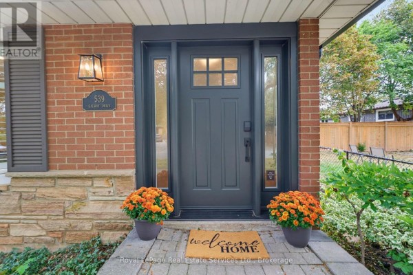 Close-up of the dark gray front door with glass panels and house number 539. - 539 Galway Drive, Burlington