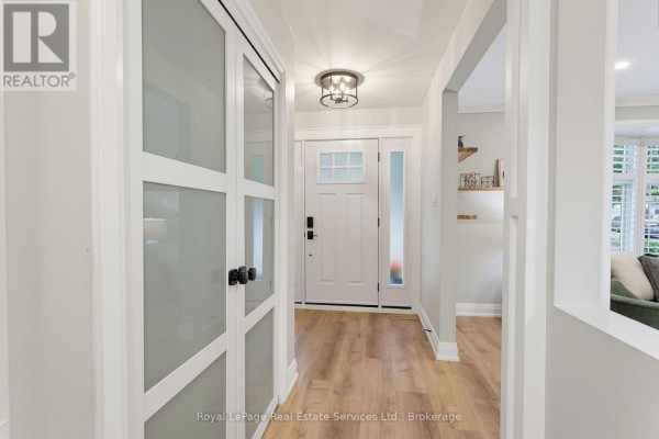 Interior entryway with light wood flooring, white walls, and frosted glass closet doors. - 539 Galway Drive, Burlington