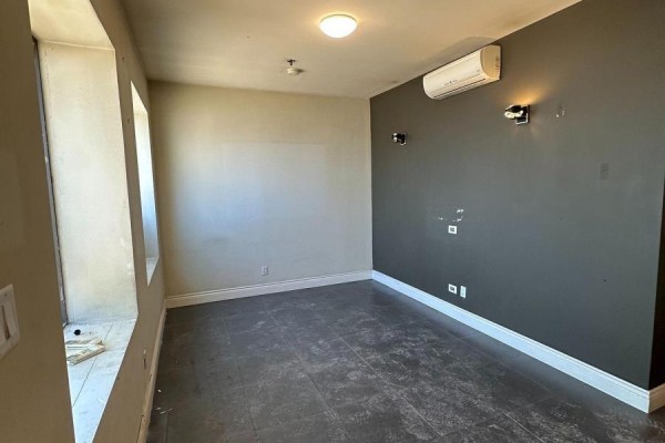 Small interior room with dark gray and beige walls, and air conditioning unit. - 54 - 173 Advance Boulevard, Brampton