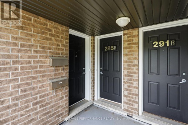 Three black entry doors with gold numbers 285B and 291B and mailboxes on a brick wall. - B - 285 Titanium Private, Ottawa