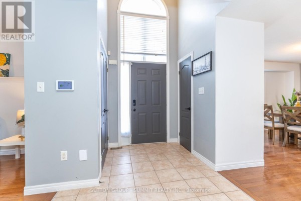 Foyer with tiled floor, tall arched window, and gray walls. - 54 - 4055 Forest Run Avenue S, Burlington